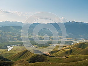 Mountain nature landscape of grassy green meadow on blue sky background