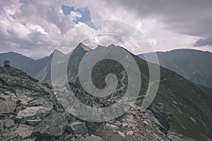 Horská panoráma z vrcholu baníkov v slovenských tatrách so skalnatou krajinou a tieňmi turistov za jasného dňa