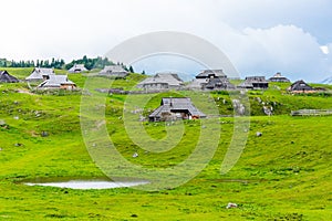 Mountain pastures on Velika Planina Big Plateau near city Kamnik in Slovenia alps. Mountain cottage hut or house on idyllic hill