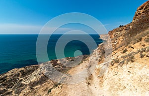 Mountain path on the rocky shore of the turquoise sea. Cape Fiolent, Sevastopol