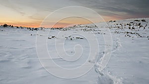 Mountain path in snow at the sunset