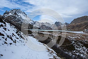 Mountain path with snow with a view of the Silvretta dam in Austria