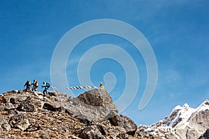 Mountain Peak with buddhist prayer Flags and Climbers walking