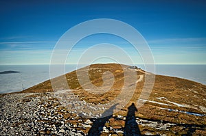 mountain peak Klosterwappen Kaiserstein Schneeberg with sea of clouds, silhouettes and blue sky