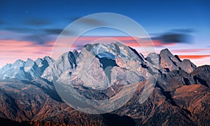 Mountain peak lighted by moonlight in autumn at night