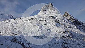 Mountain peak near Visitor centre on Trollstigen road in snow in Norway in autumn