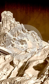 Mountain peak and snowy valley in winter season against a beautiful sunny blue sky