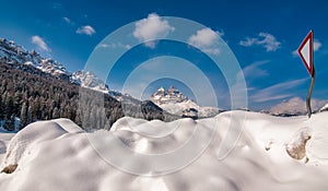 Mountain peak and snowy valley in winter season against a beautiful sunny blue sky
