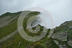 A mountain peak veiling from one side into the mist