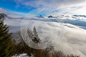 Mountain peaks of Alps above layers of clouds drifting in Austria, Europe.