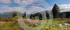 Mountain peaks in bright sunlight. Wooden constructions for training on a meadow