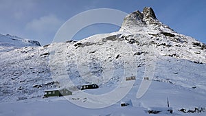 Mountain peaks and huts near Visitor centre on Trollstigen road in snow in Norway in autumn