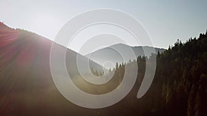 Mountain peaks and morning sky with smooth moving clouds. Summer landscape paeceful valley trees in the meadow at