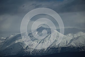 mountain pick with snow on top clouds ice winter background in mitsikeli mountain grreece