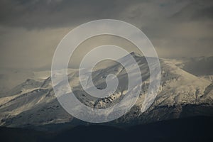 mountain pick with snow on top clouds ice winter background in mitsikeli mountain grreece