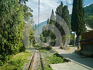 Mountain railway in summer, the greenery disappearing into the distance in the Caucasus, at the railway station