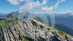 Mountain range alpine meadows on southern slope with clouds in the sky on a sunny day, gorges and peaks extending into the distan.