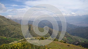 Mountain range with nearby bushes and cloudy sky