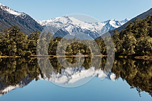 Mountain range reflecting in lake in Southern Alps in New Zealand photo