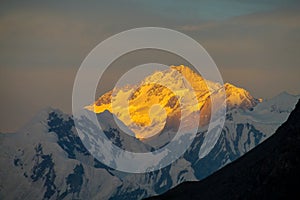 Mountain range snow peaks under orange sunset clouds