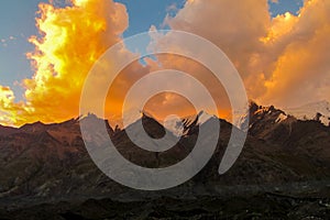 Mountain range snow peaks under orange sunset clouds