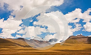 Mountain range on a sunny day is covered with clean white clouds