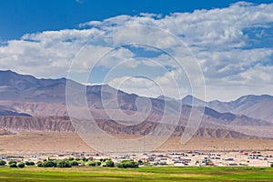 Mountain ranges,desert,pasture,village and cloudscape