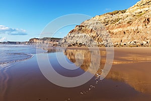 Mountain reflected in the smooth water of the beach Areia Branca. Lourinha, Portugal, photo