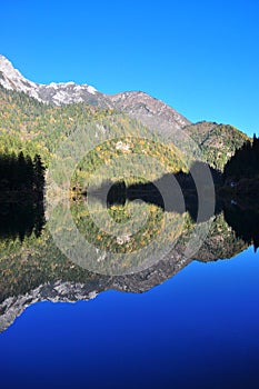 Mountain with reflection on a lake during Autumn