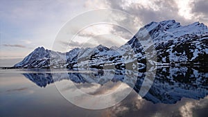 Mountain reflections at Sundstraumen on the Lofoten in winter in Norway at sunset