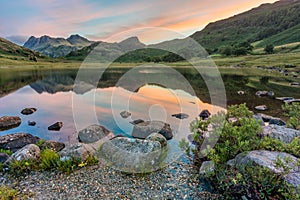 Mountain reflections at sunrise. Blea Tarn, Lake District, UK.