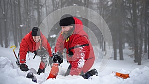 Mountain rescue service on successful operation outdoors in winter in forest, snow and avalanche concept.