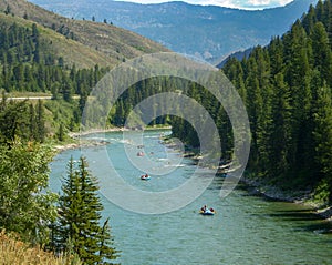 Mountain river filled with many people river rafting.