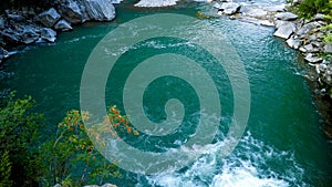 Mountain river flowing in beautiful lake with clear emerald water in mountains