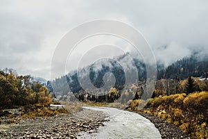 Mountain river flows among mountains in fog and forest 3