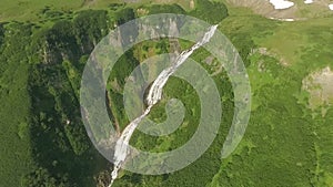 Mountain river flows into a waterfall. View of the waterfall from the bird`s flight.