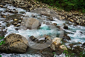 Mountain River rages on rocks on a cloudy day