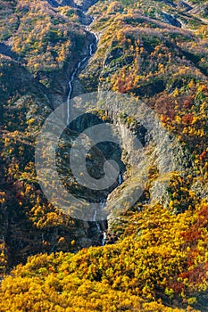 Mountain river running down the mountain among the autumn cliffs