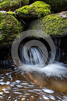 Mountain river running through a forest and over rocks nearby in the Sierra de Madrid