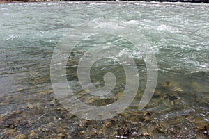 A mountain river with rushing water from the melting snow