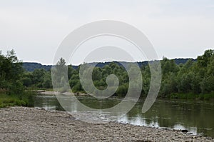 The mountain river with stones ashore