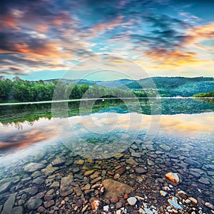 Mountain river stream of water in the rocks with majestic sunset