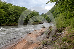 mountain river swift current, whirlpools in the flow of water in a granite canyon photo