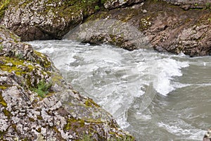 mountain river swift current, whirlpools in the flow of water in a granite canyon photo