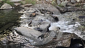Mountain river water flowing over pebbles and rocks