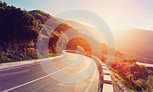 Mountain road. beautiful asphalt road in the evening in summer during sunset. Vintage toning. Travel background. Highway in