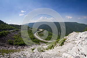 Mountain road with a car moving along it