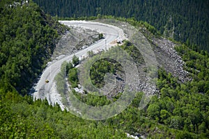 Mountain road with a car moving along it