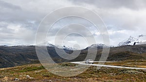 Mountain road and car, snow peaks Norway landscape