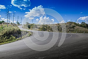 Mountain road in day with a blue sky with clouds